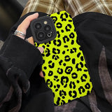 a person holding a cell case with a yellow leopard print