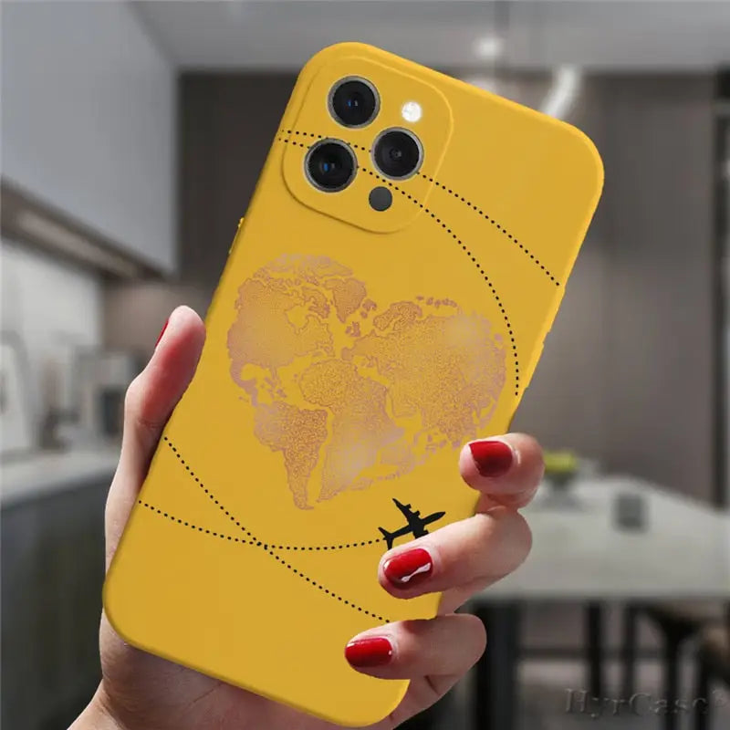 a woman holding a yellow phone case with a world map on it