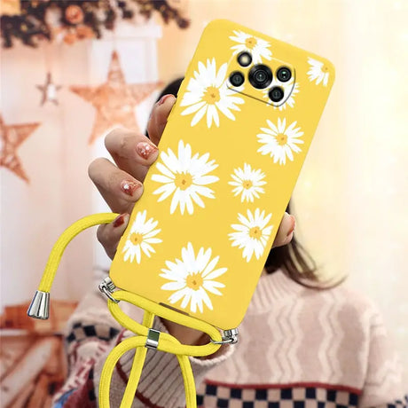 a woman holding a yellow phone case with white flowers on it