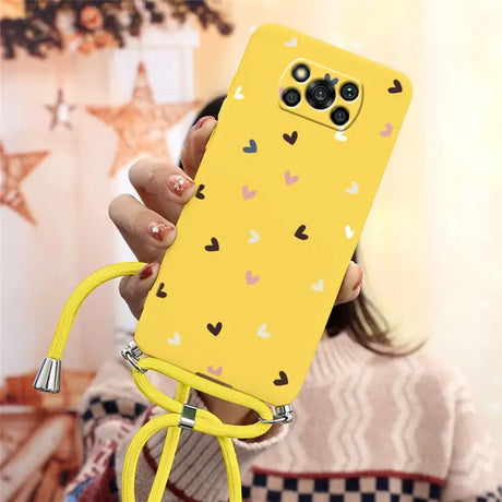 a woman holding a yellow phone case with hearts on it