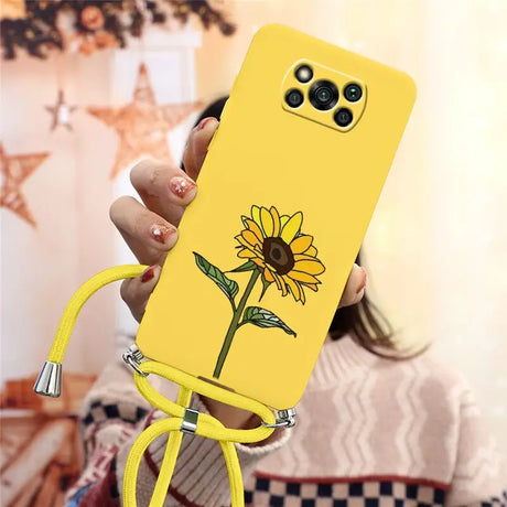 a woman holding a yellow phone case with a flower