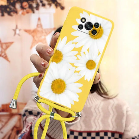 a woman holding a yellow phone case with white flowers on it