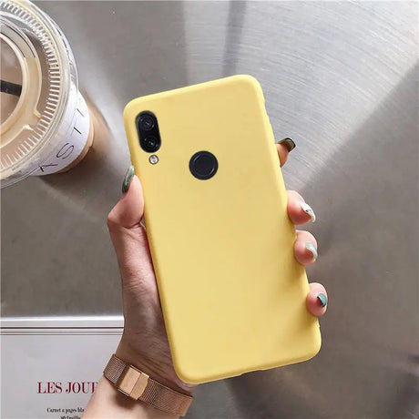 a woman holding a yellow phone case