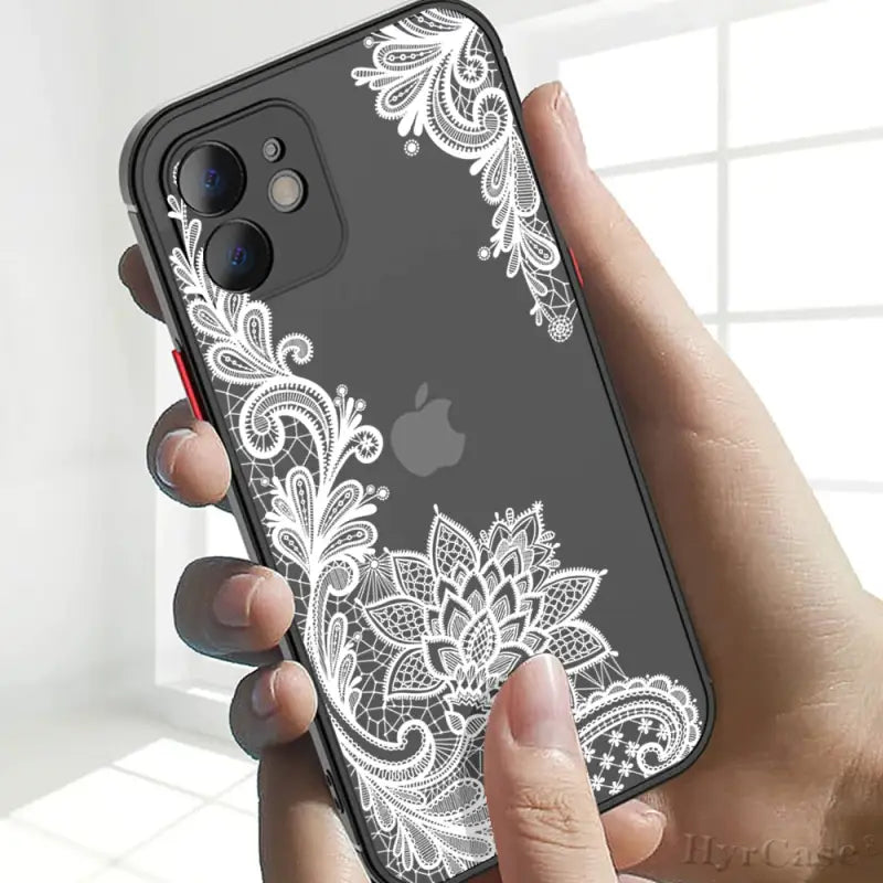 a woman holding an iphone case with a white lace pattern on it