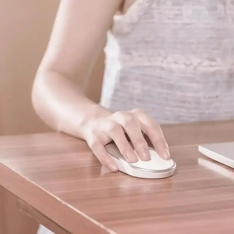 a woman using a mouse on a desk