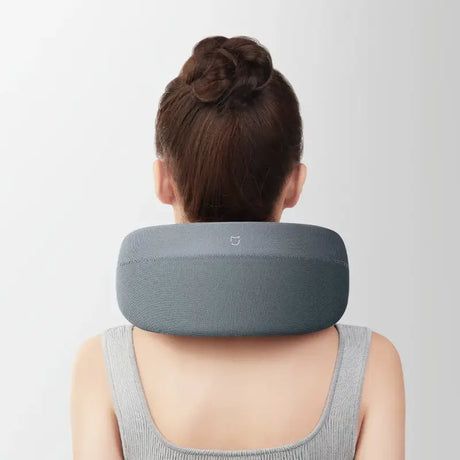 A woman wearing a neck pillow