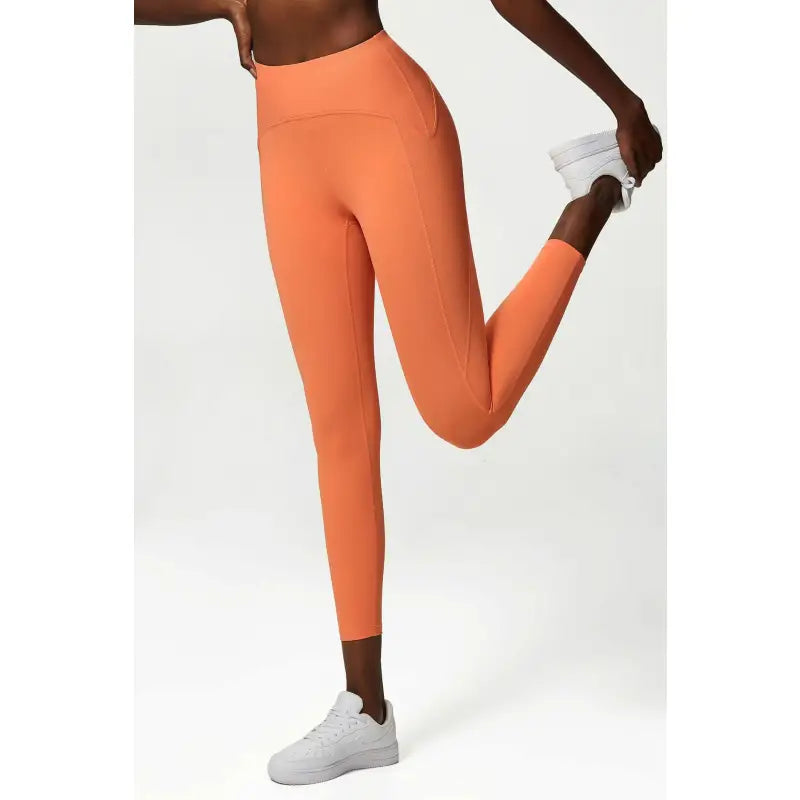 a woman in orange leggings and white sneakers