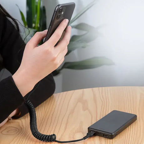 A woman is holding a phone and charging it