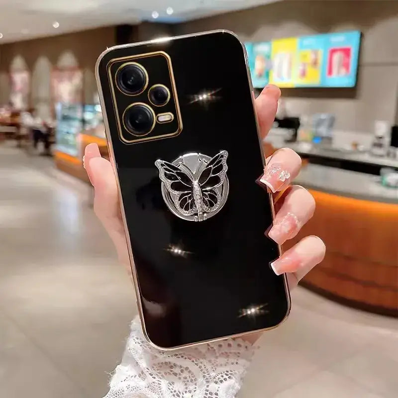 A woman holding a phone with a butterfly on it