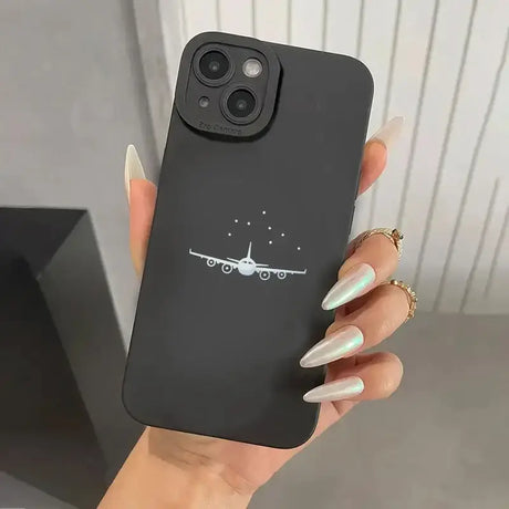 A woman holding a phone case with an airplane drawn on it