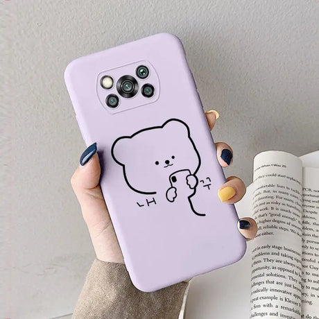 a woman holding a phone case with a drawing of a bear