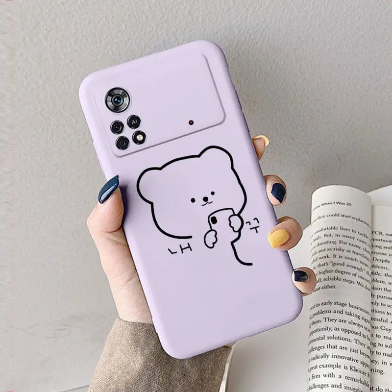 a woman holding a phone case with a drawing of a bear