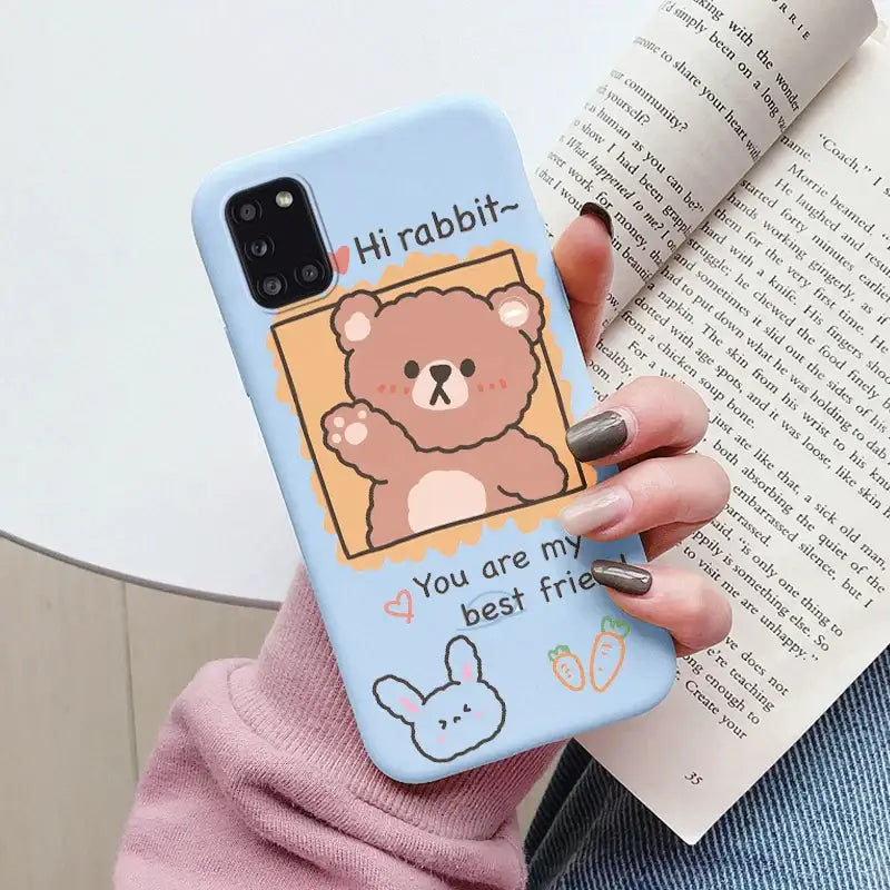 A woman holding a phone case with a bear on it