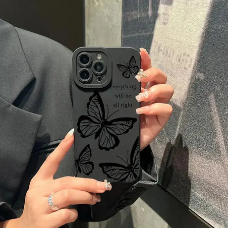 A woman holding a phone case with a black butterfly design