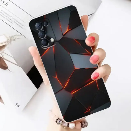 A woman holding a phone case with a black and red geometric design