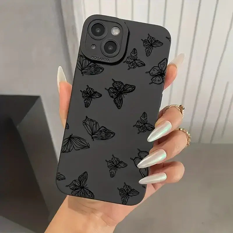 a woman holding a phone case with a black and white pattern