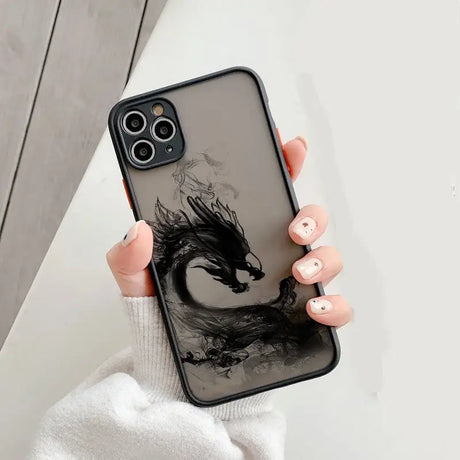 A woman holding a phone case with a black dragon on it