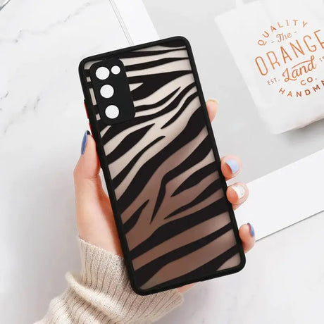 A woman holding a phone case with a black and white zebra print