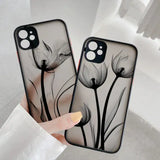 a woman holding a phone case with a black and white flower design