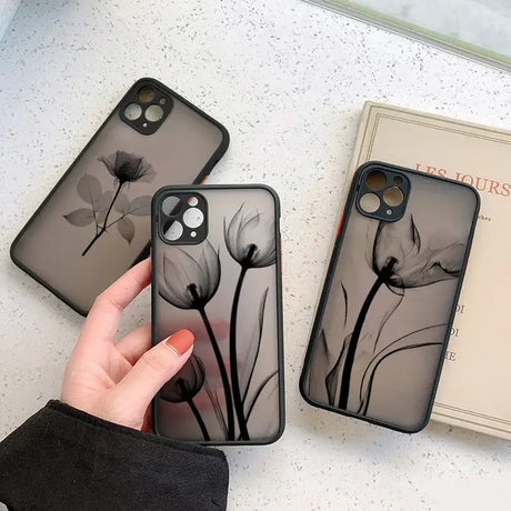 A woman holding a phone case with a black flower design