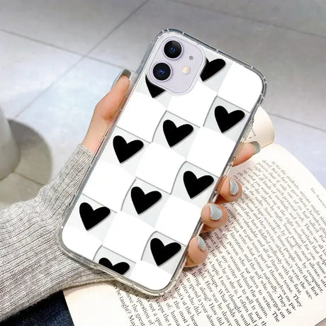 A woman holding a phone case with black hearts on it