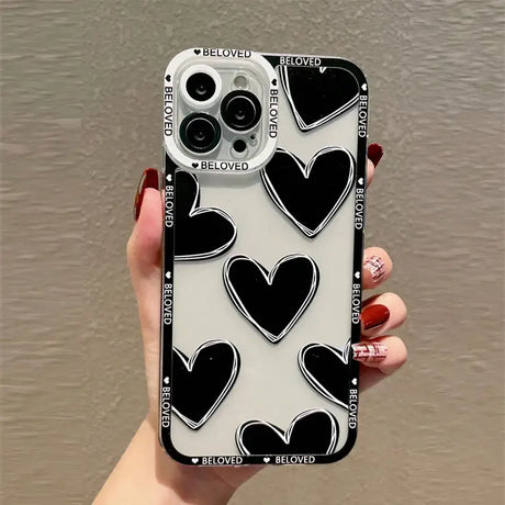 A woman holding a phone case with black and white hearts