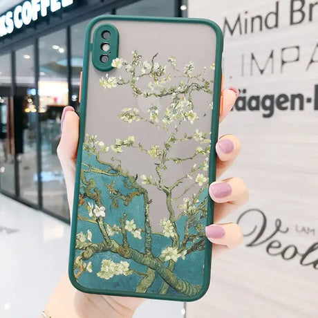 A woman holding a phone case with a blossom blossom tree