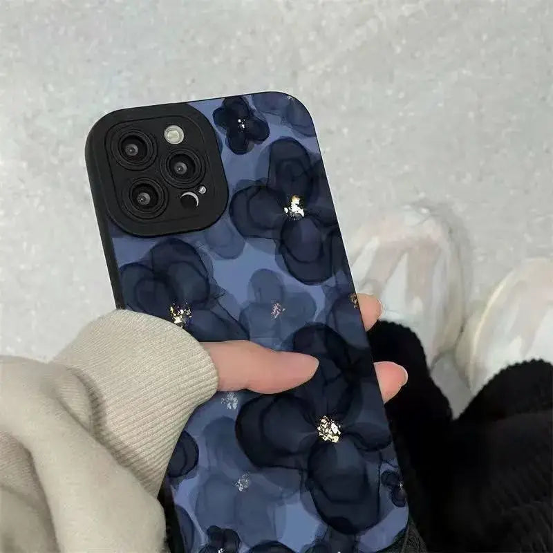 a woman holding a phone case with a blue floral pattern