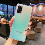 A woman holding up a phone case with a blue and green om
