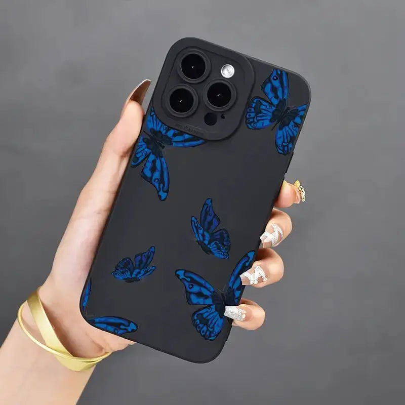 A woman holding a phone case with blue butterflies on it