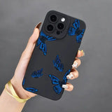 a woman holding a phone case with blue butterflies on it