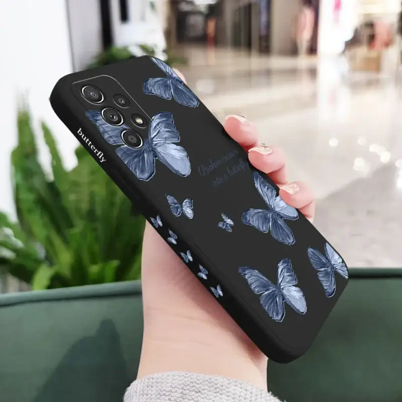 A woman holding a phone case with a blue butterfly pattern