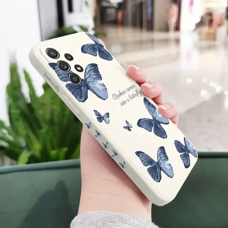 A woman holding a phone case with blue butterflies on it