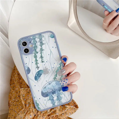 A woman holding a phone case with a blue and white floral design