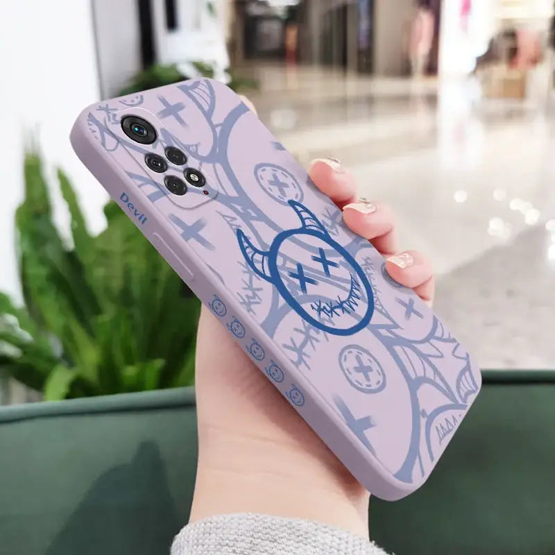 a woman holding a phone case with a blue design