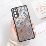 a woman holding a phone case with blue leaves on it