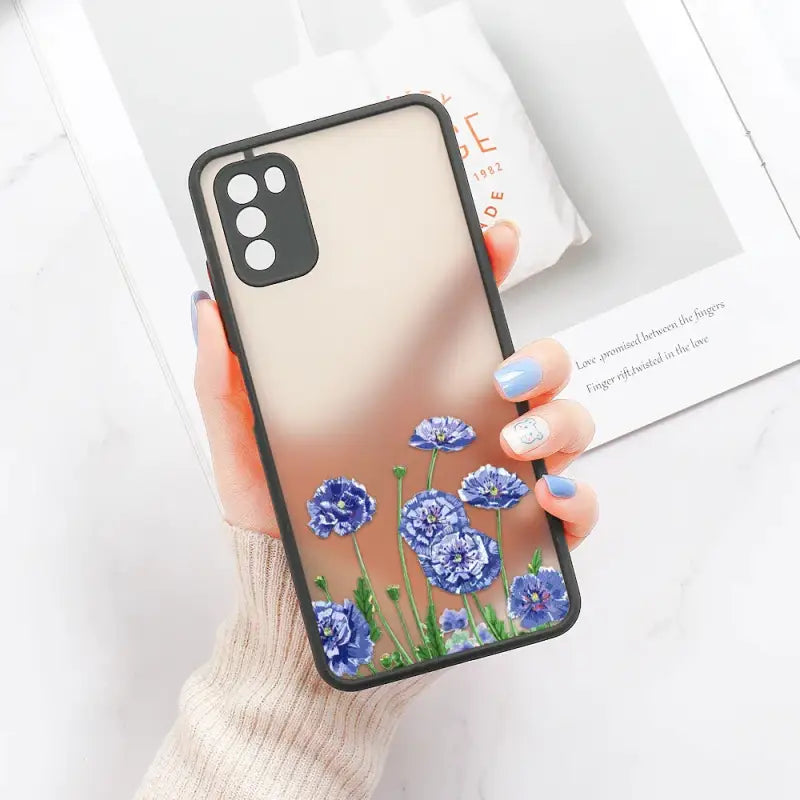 a woman holding a phone case with blue flowers