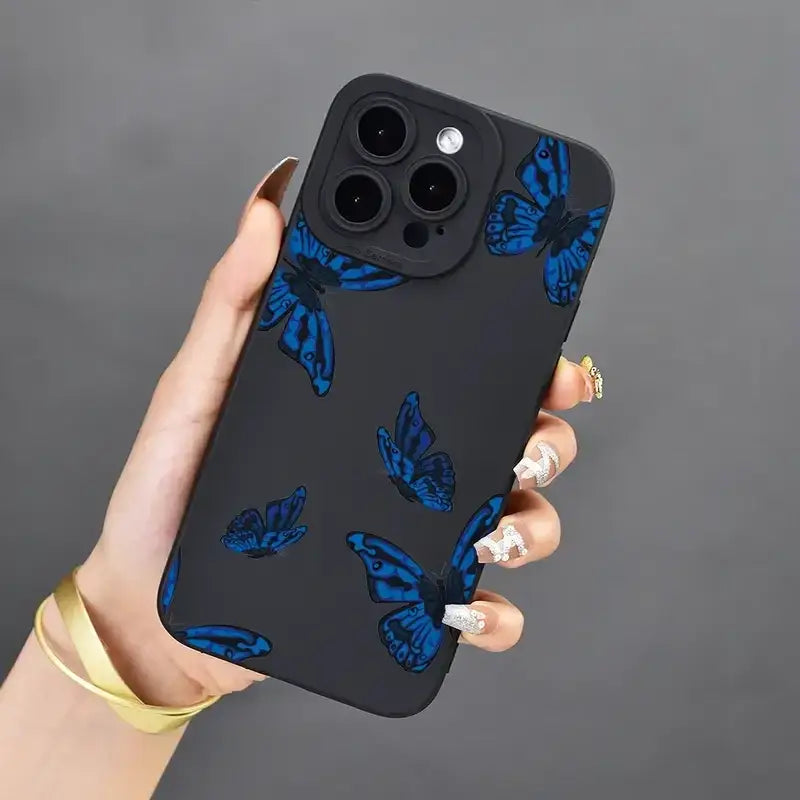 A woman holding a phone case with blue butterflies on it