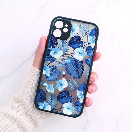 A woman holding a phone case with blue flowers on it