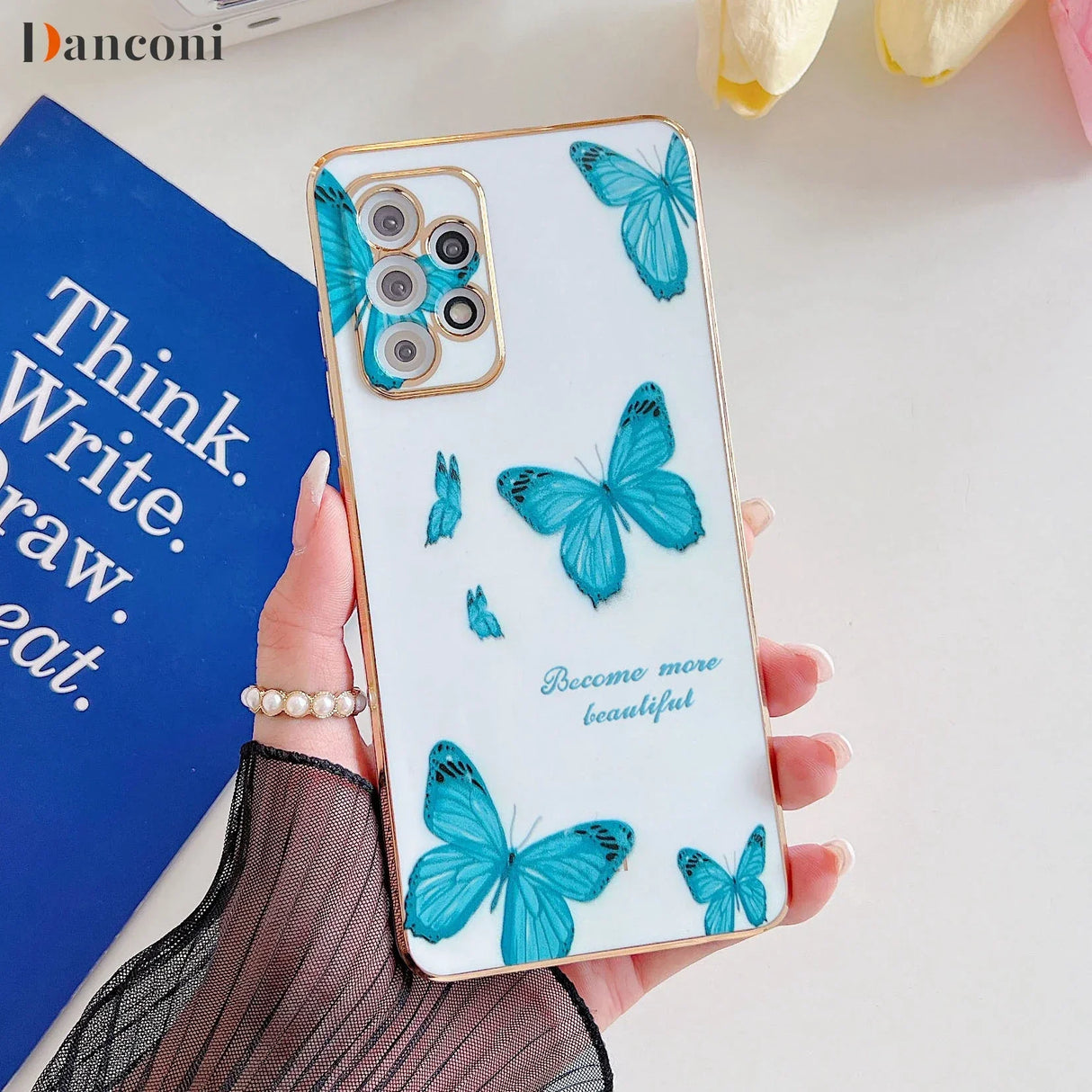 a woman holding a phone case with blue butterflies on it
