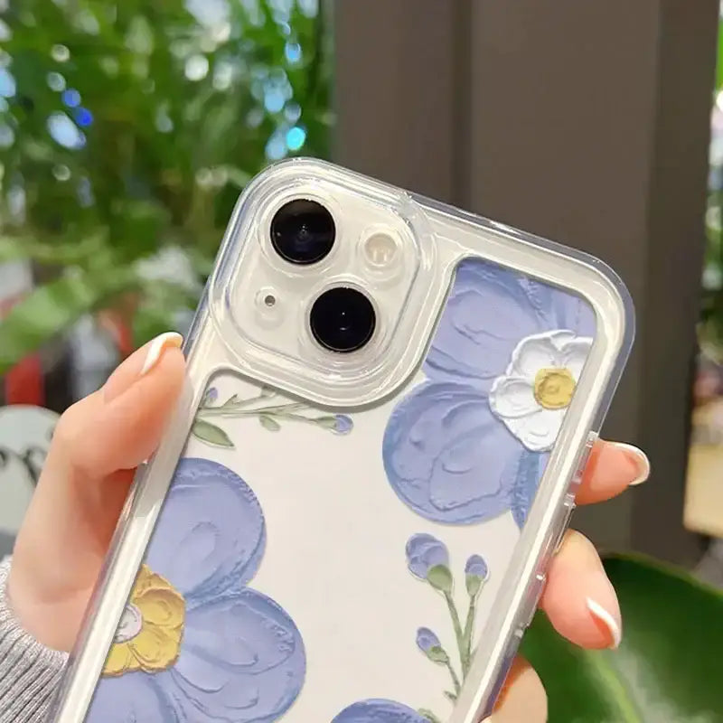 a woman holding a phone case with blue flowers on it