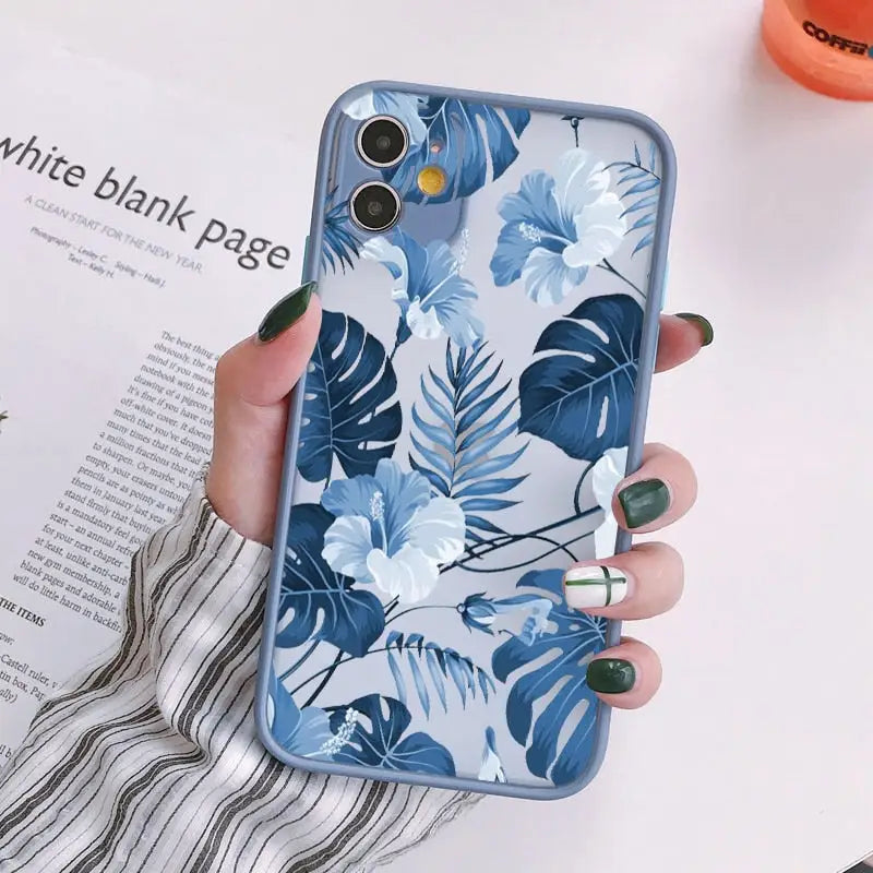 a woman holding a phone case with blue flowers