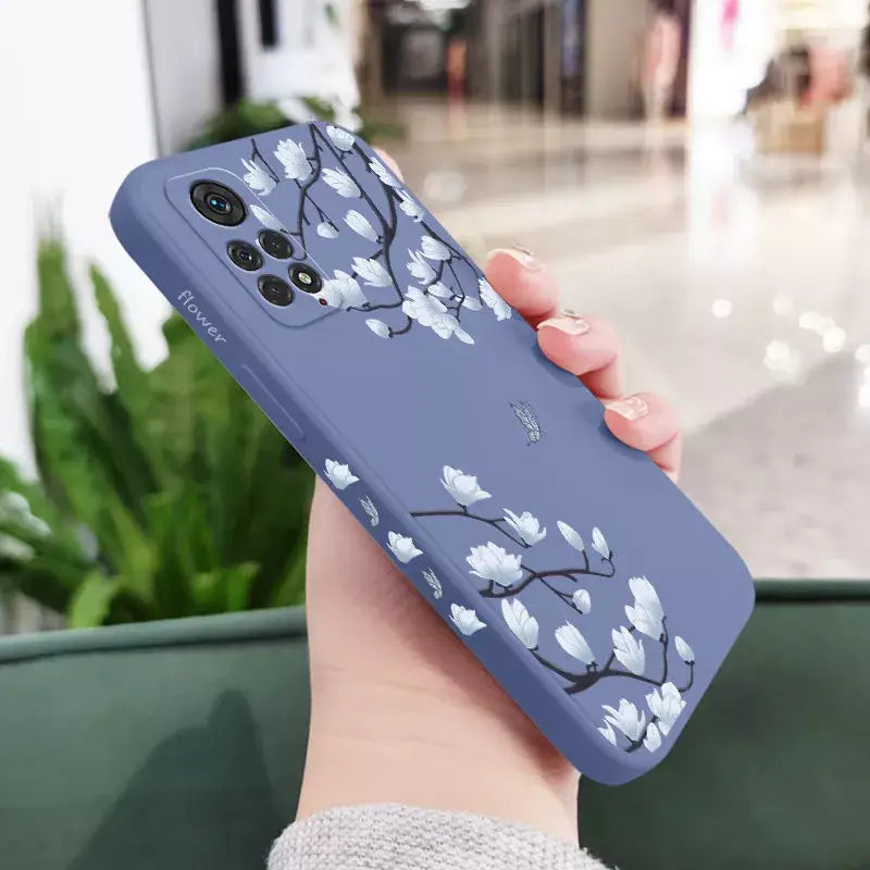 a woman holding a phone case with a blue flower design