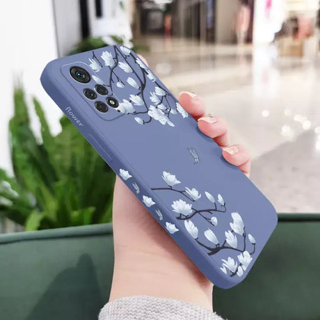 A woman holding a phone case with a blue flower design