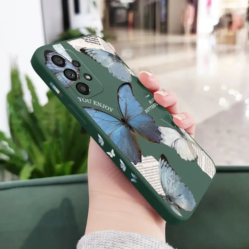 a woman holding a phone case with a blue butterfly on it