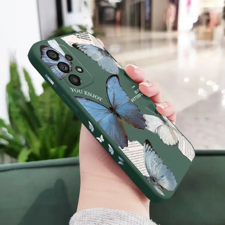 A woman holding a phone case with a blue butterfly on it