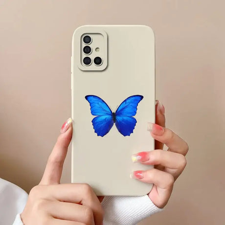 a woman holding a phone case with a blue butterfly on it