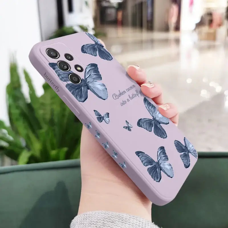 a woman holding a phone case with butterflies on it