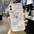 A woman holding a phone case with butterflies on it