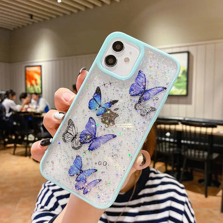 A woman holding up a phone case with butterflies on it